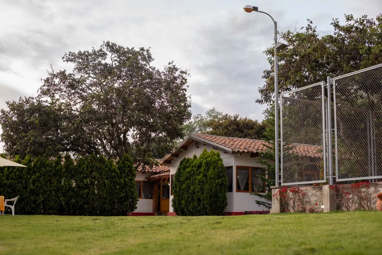 Tile-roofed bungalow beside wide lawns and the sports court