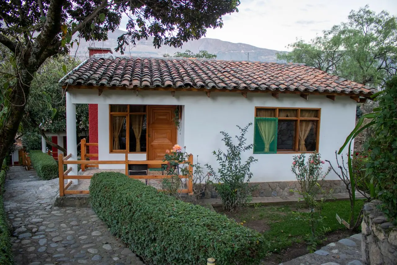 Tile-roofed bungalow with wooden windows beside the garden