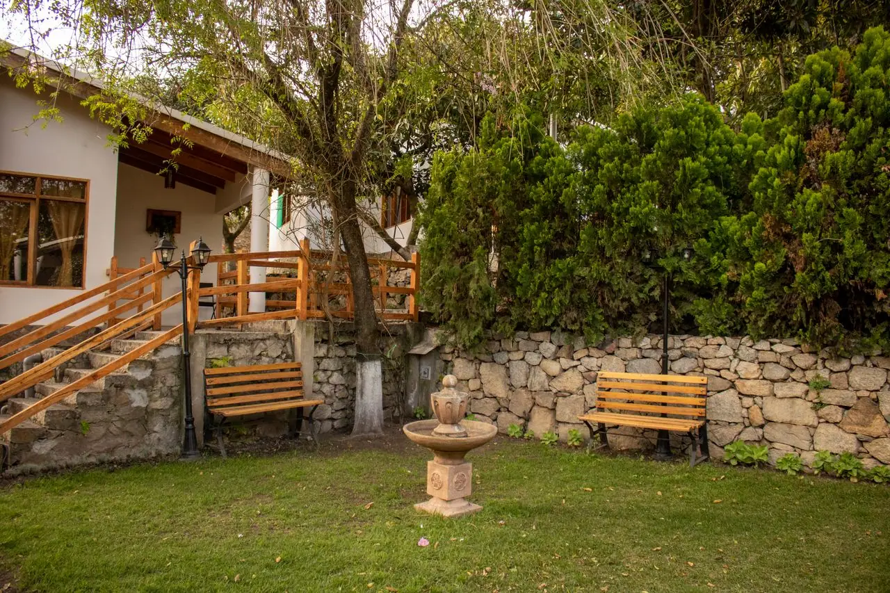 Cabin with a wooden deck, benches and a stone fountain