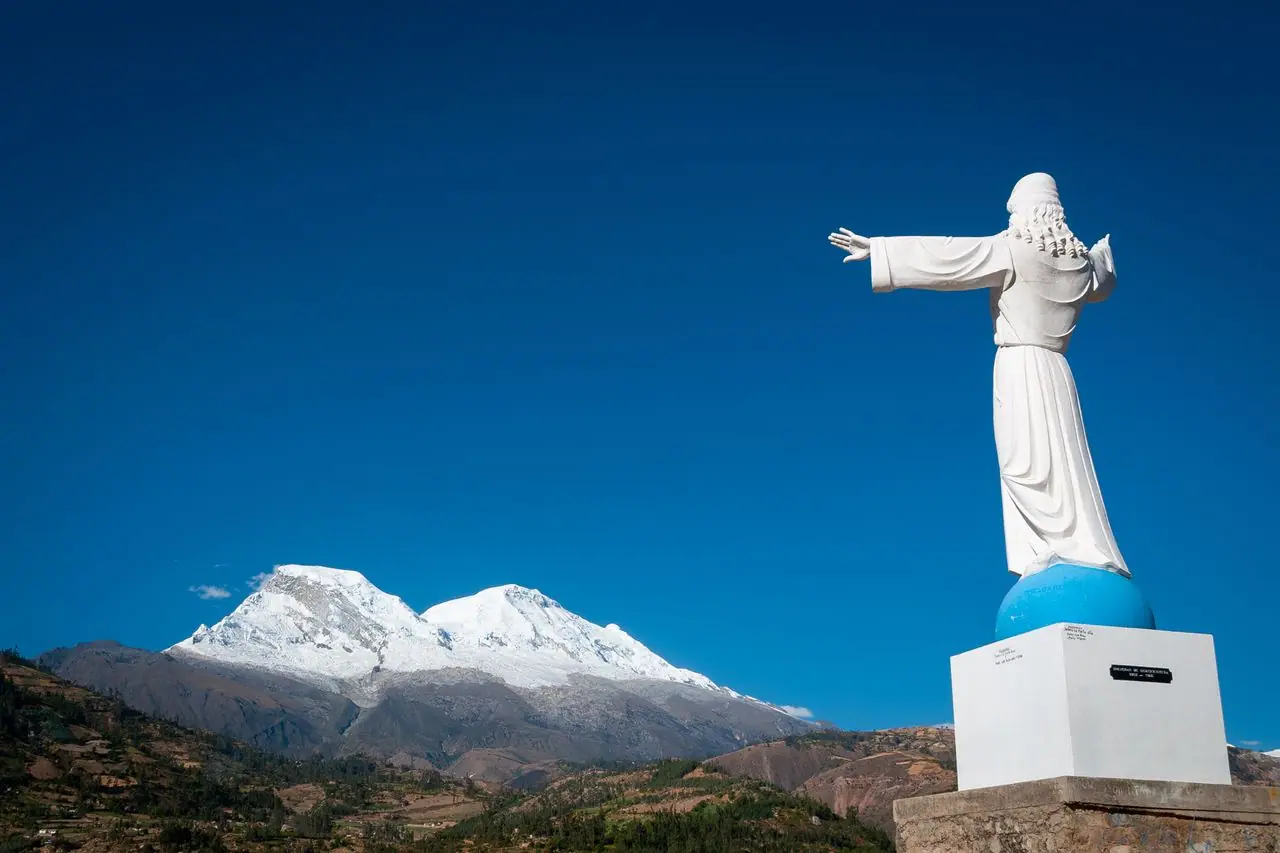 The Christ of Yungay with snow-capped peaks beyond