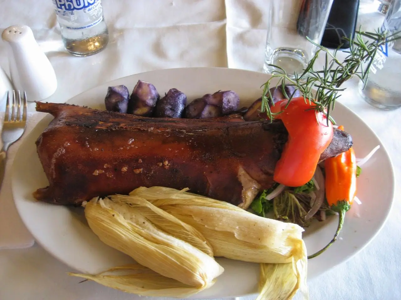 Cuy al horno servido con papas y choclo, plato emblemático de la sierra peruana