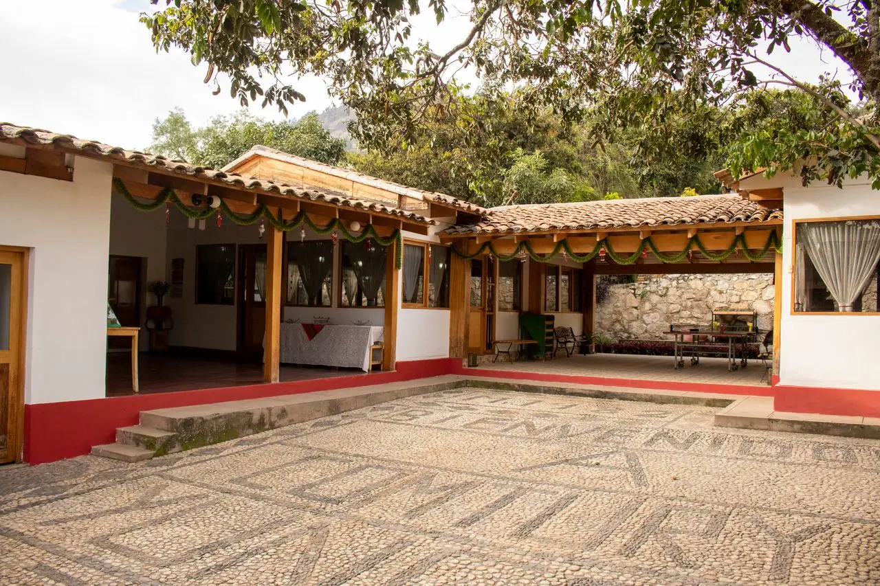 Patio de ingreso con mosaico de piedra y corredores de madera