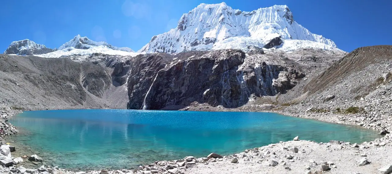 Panoramic view of Laguna 69 with the glacier and meltwater waterfall behind