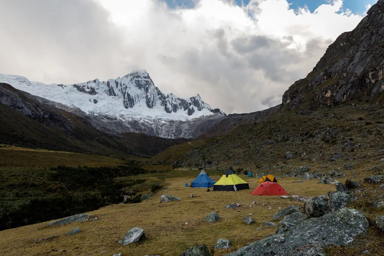 Carpas de trekking en Taullipampa con un nevado al fondo