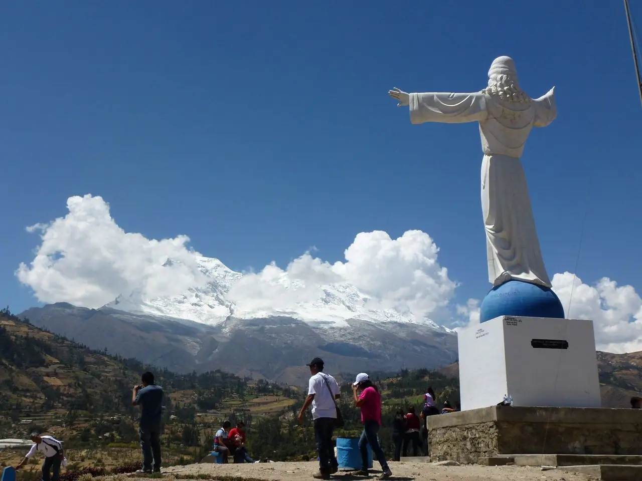 The Christ statue at Yungay’s Campo Santo with Huascarán and clouds behind