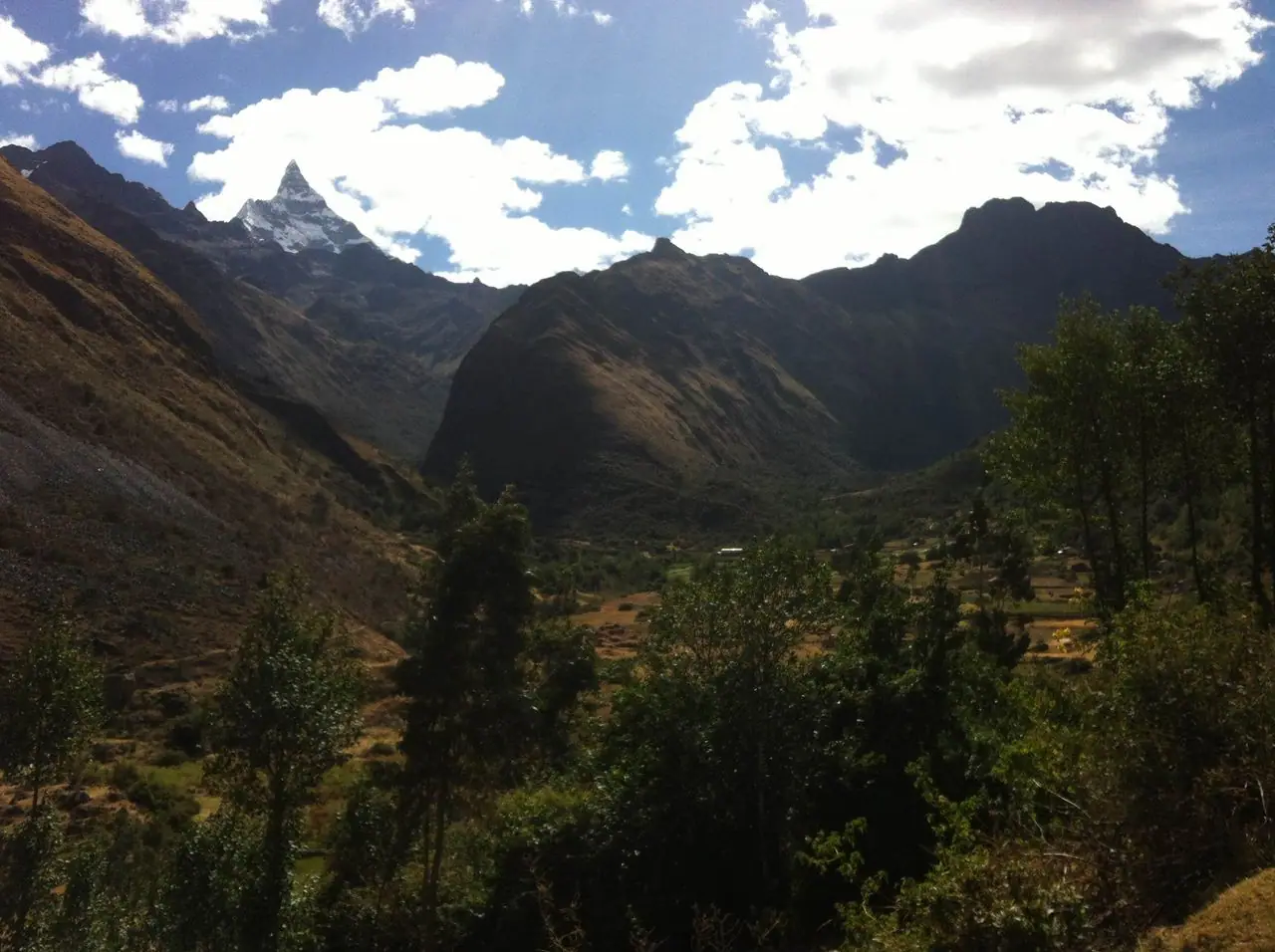 Green valley in Yungay province with clouds over the mountains